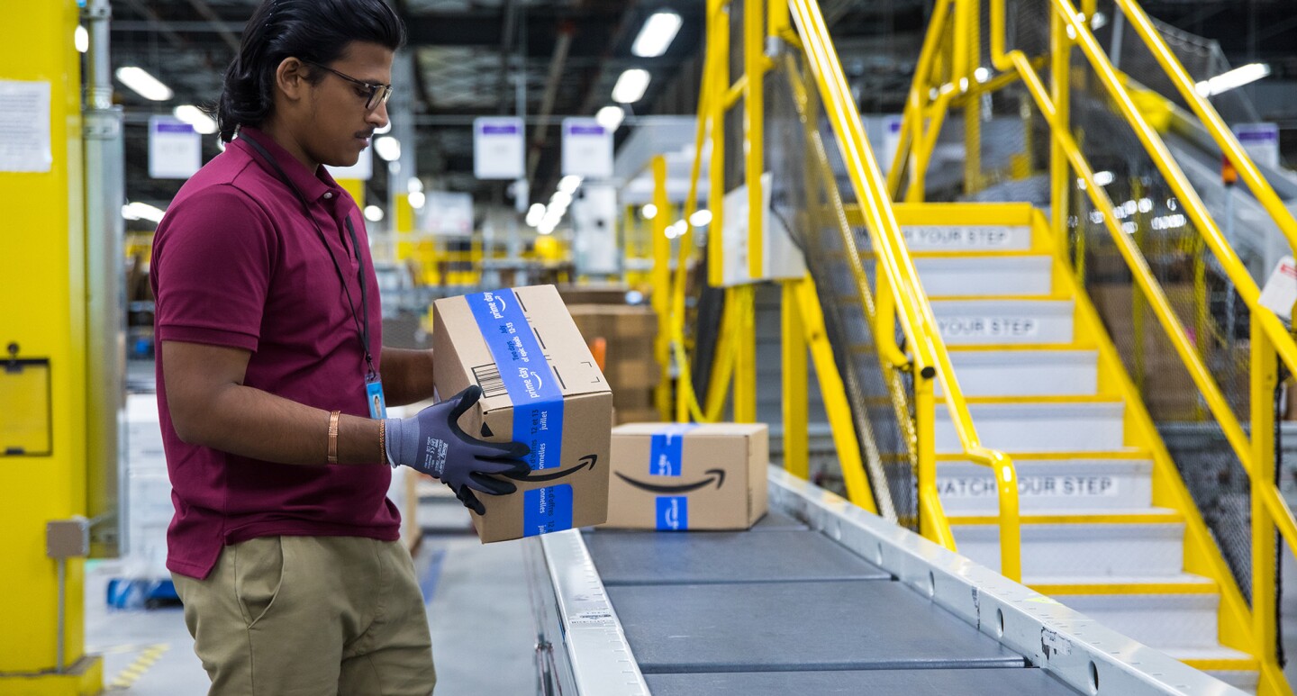 A photo of a fulfillment center employee handling a package